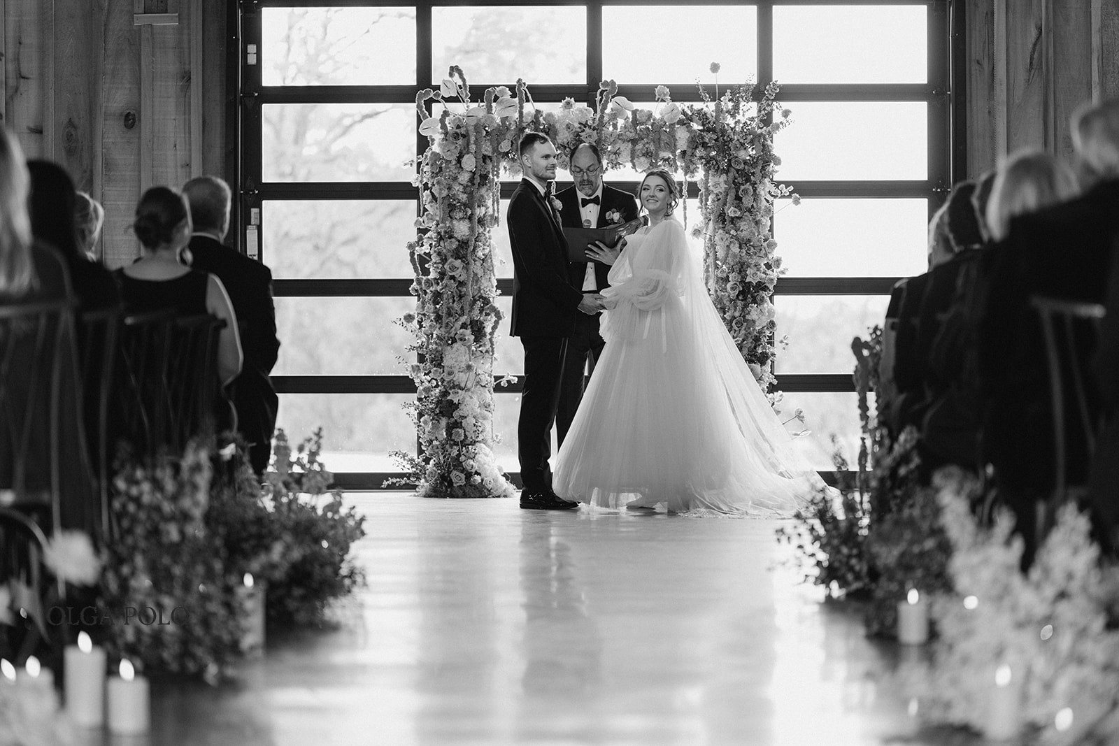 Wide view of Maia and Troy's ceremony beneath the floral installation