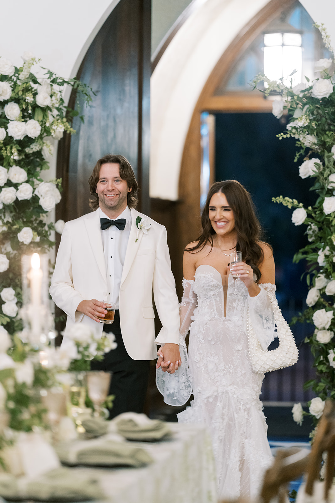 Ronnie and Patrick framed by white florals at The Palomar Cincinnati entrance