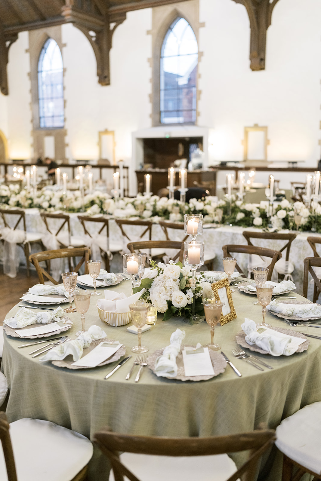Reception table set with green linens, white florals and place settings at The Palomar Cincinnati