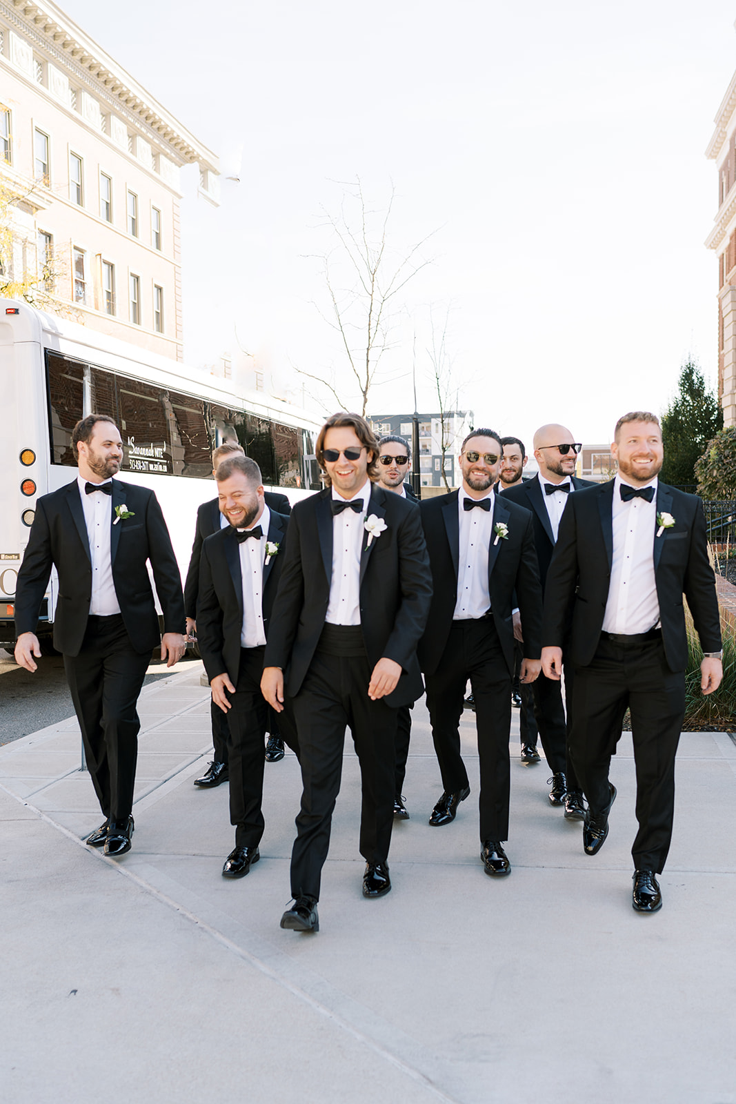 Patrick walking through Cincinnati with his groomsmen in black-tie attire