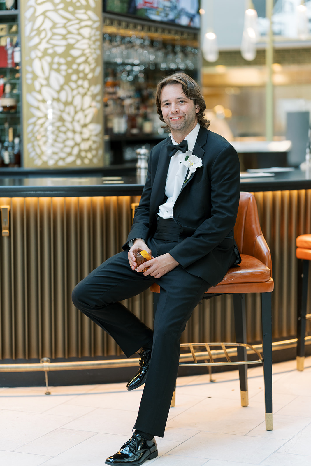 Patrick seated at a bar for a groom portrait on the wedding day