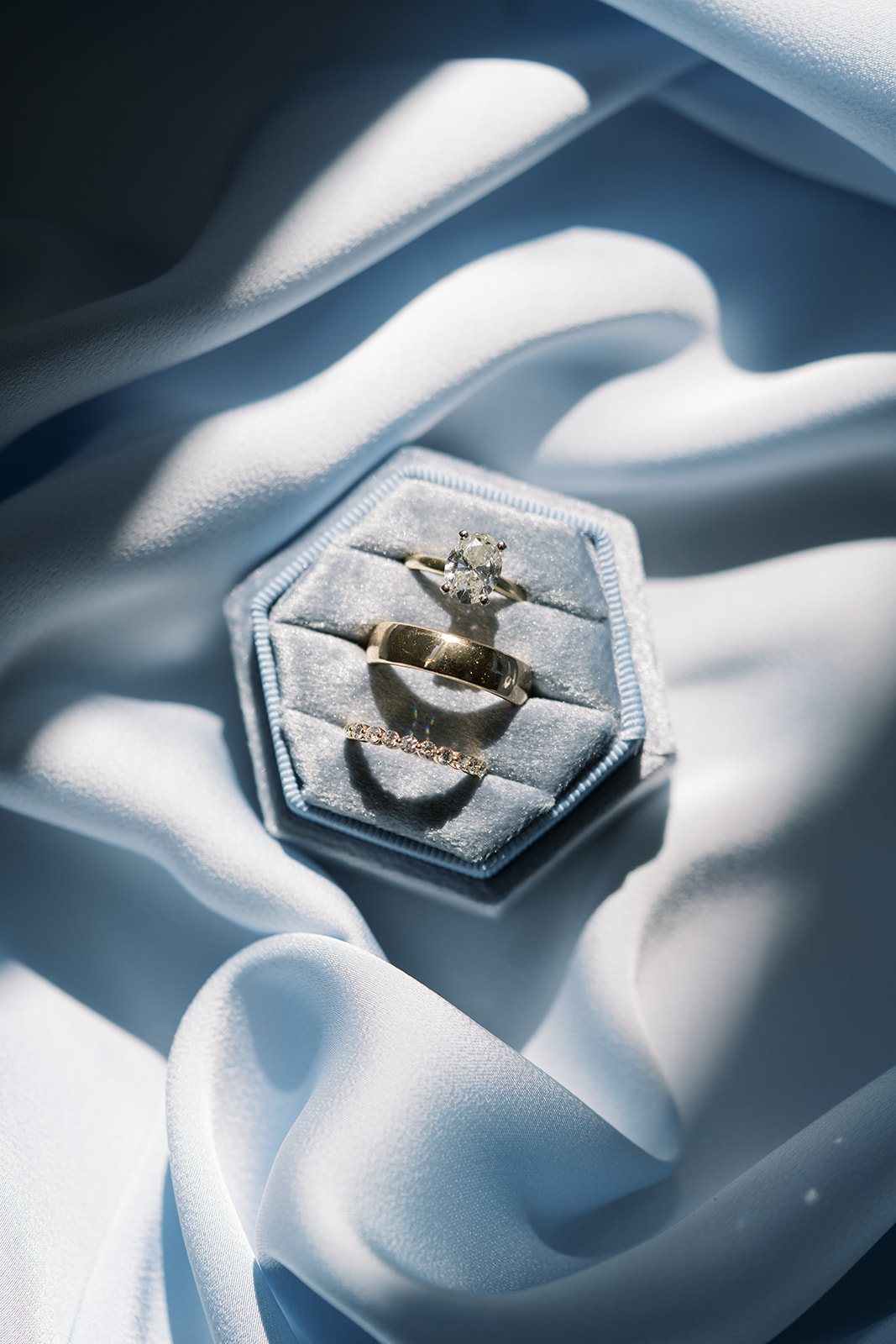 Andee & Quinn wedding at The Cincinnati Club: wedding rings blue silk flatlay.