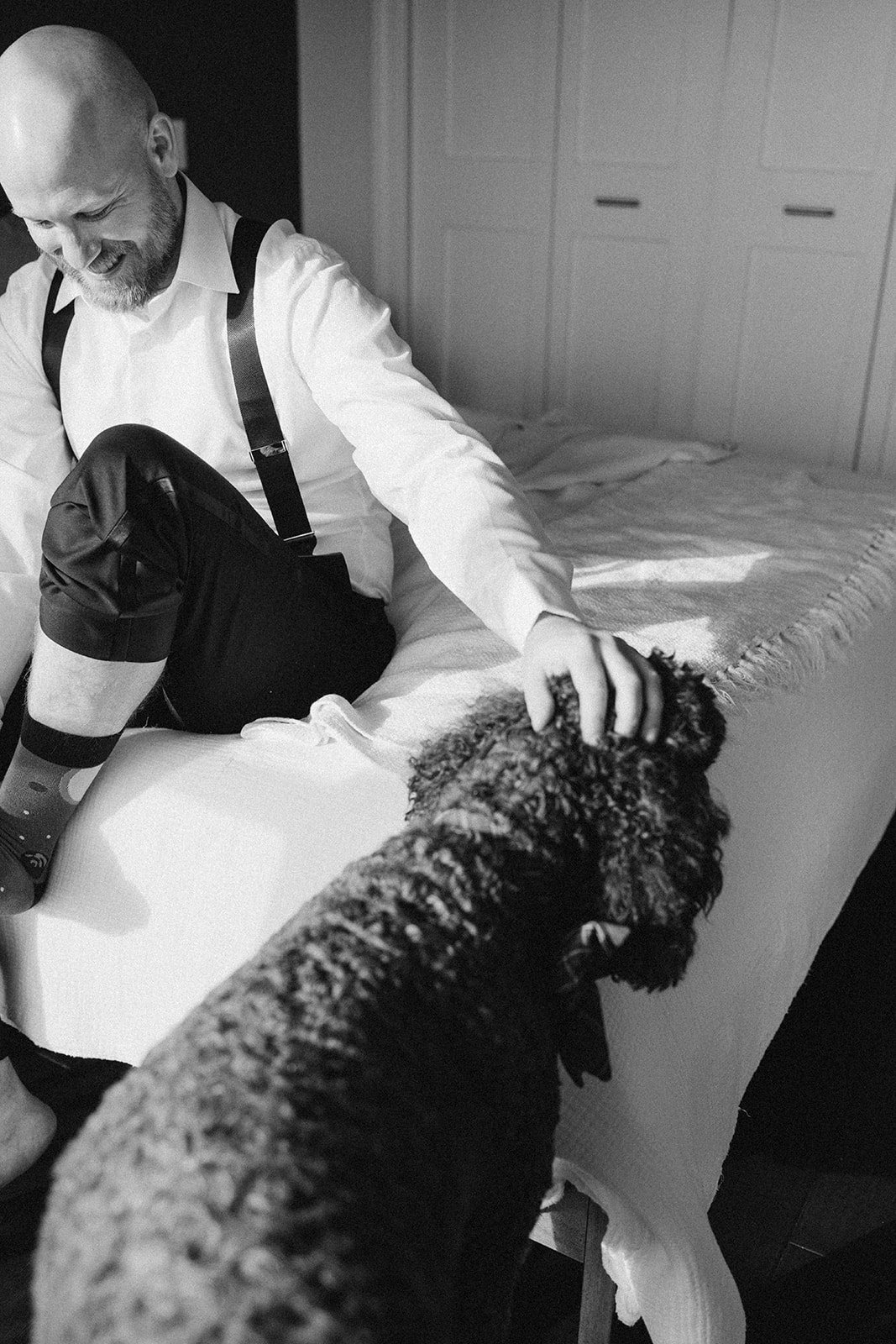 Clint and Ania wedding: groom adjusting shoes black white.