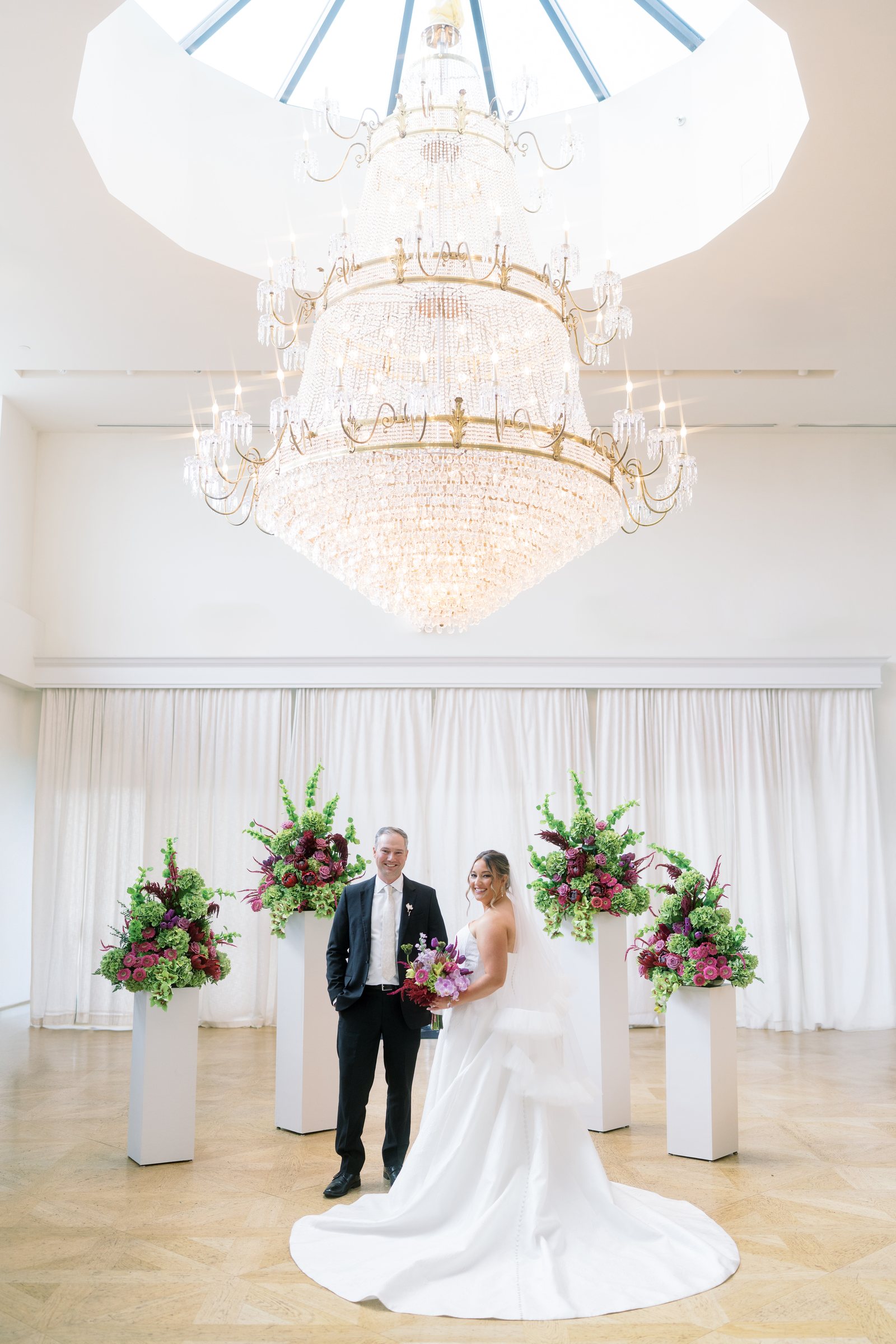 Kent and Nicolette beneath the chandelier and floral ceremony backdrop at The View at Mt. Adams