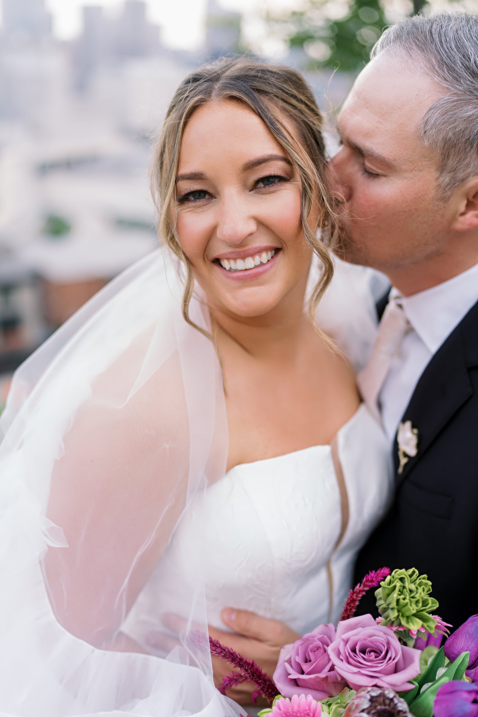 Kent and Nicolette wedding: kent kissing nicolette cheek skyline.