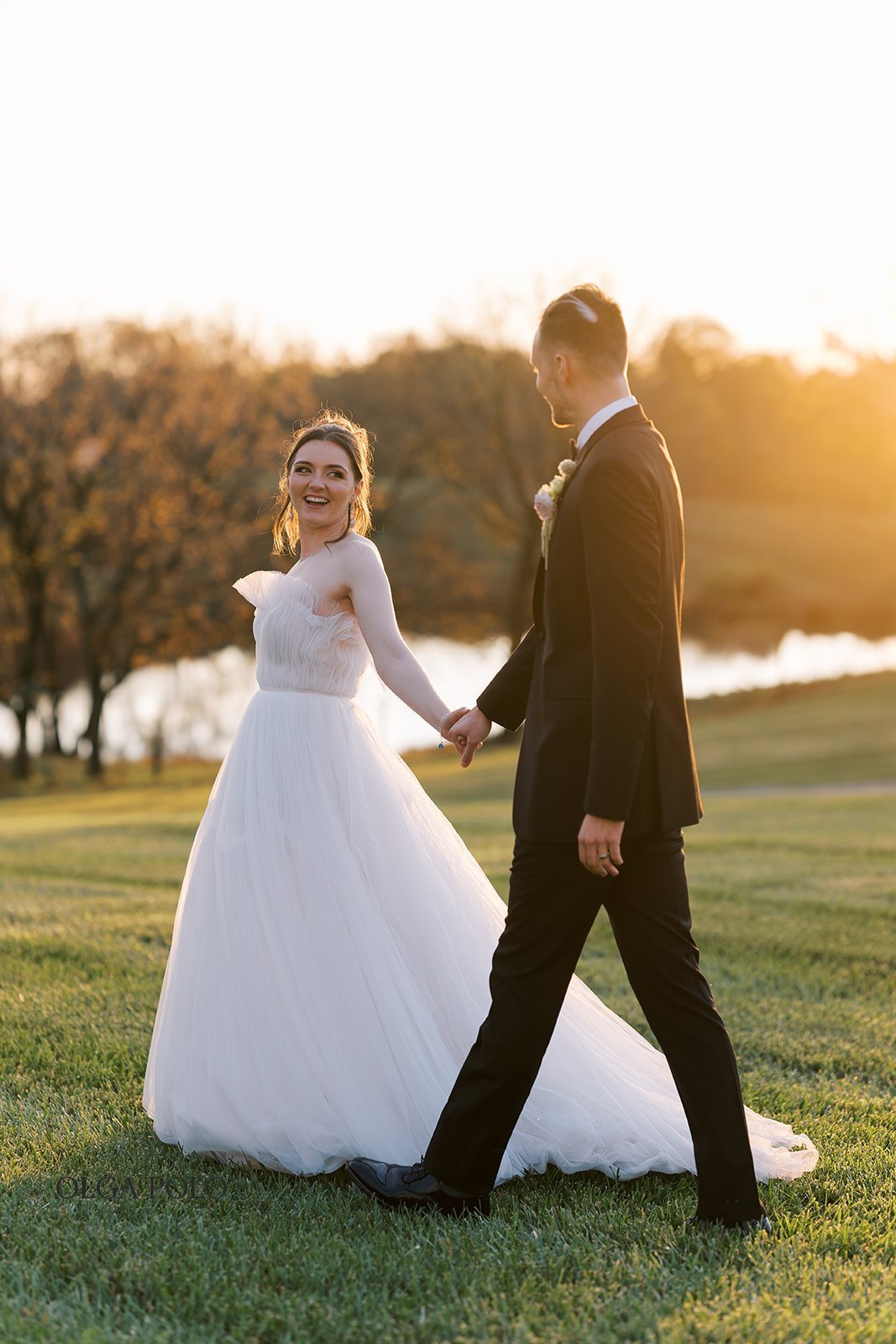 Maia and Troy walking together at sunset on their wedding day at Boone Valley Farm