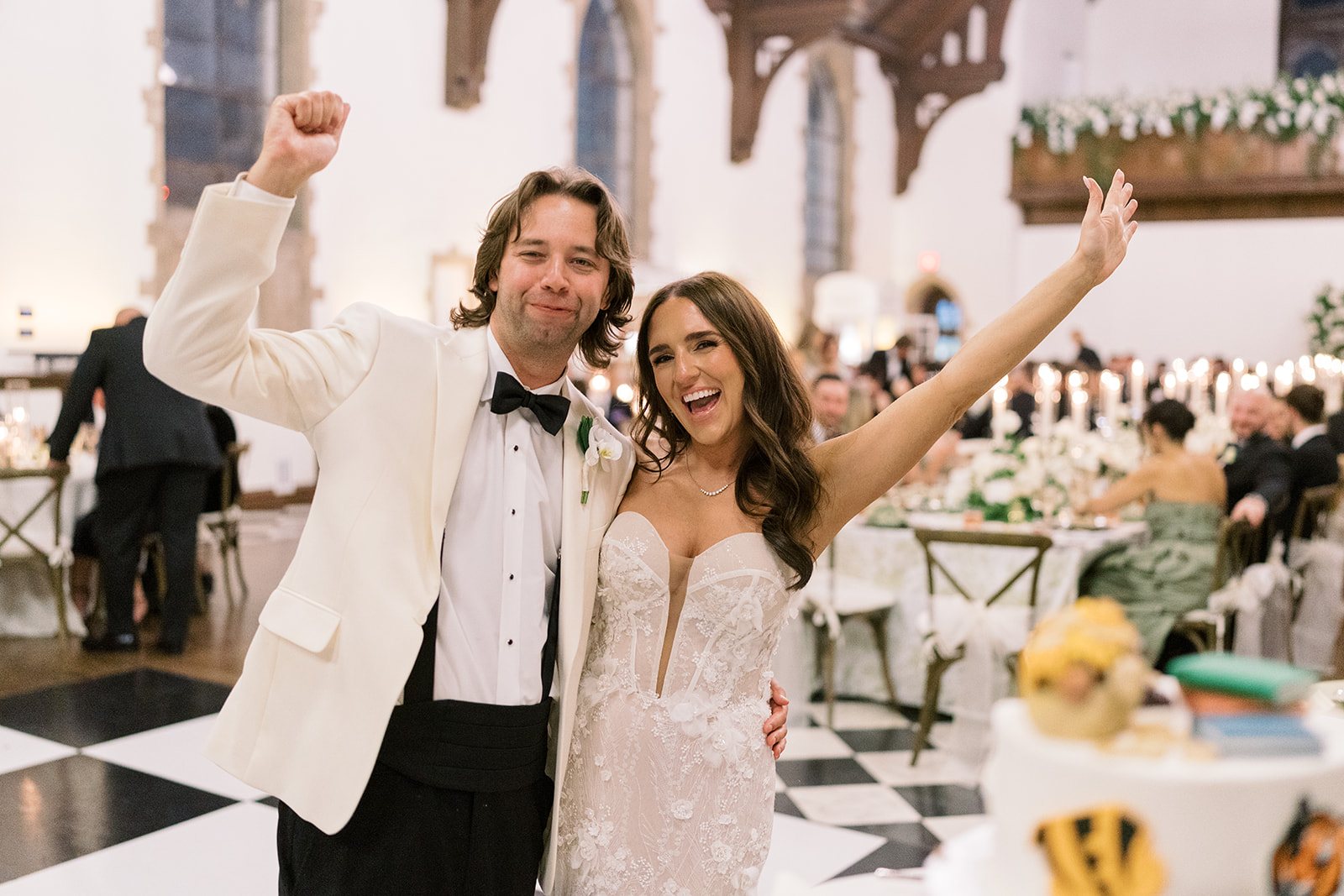Ronnie and Patrick celebrating with raised arms during their evening reception
