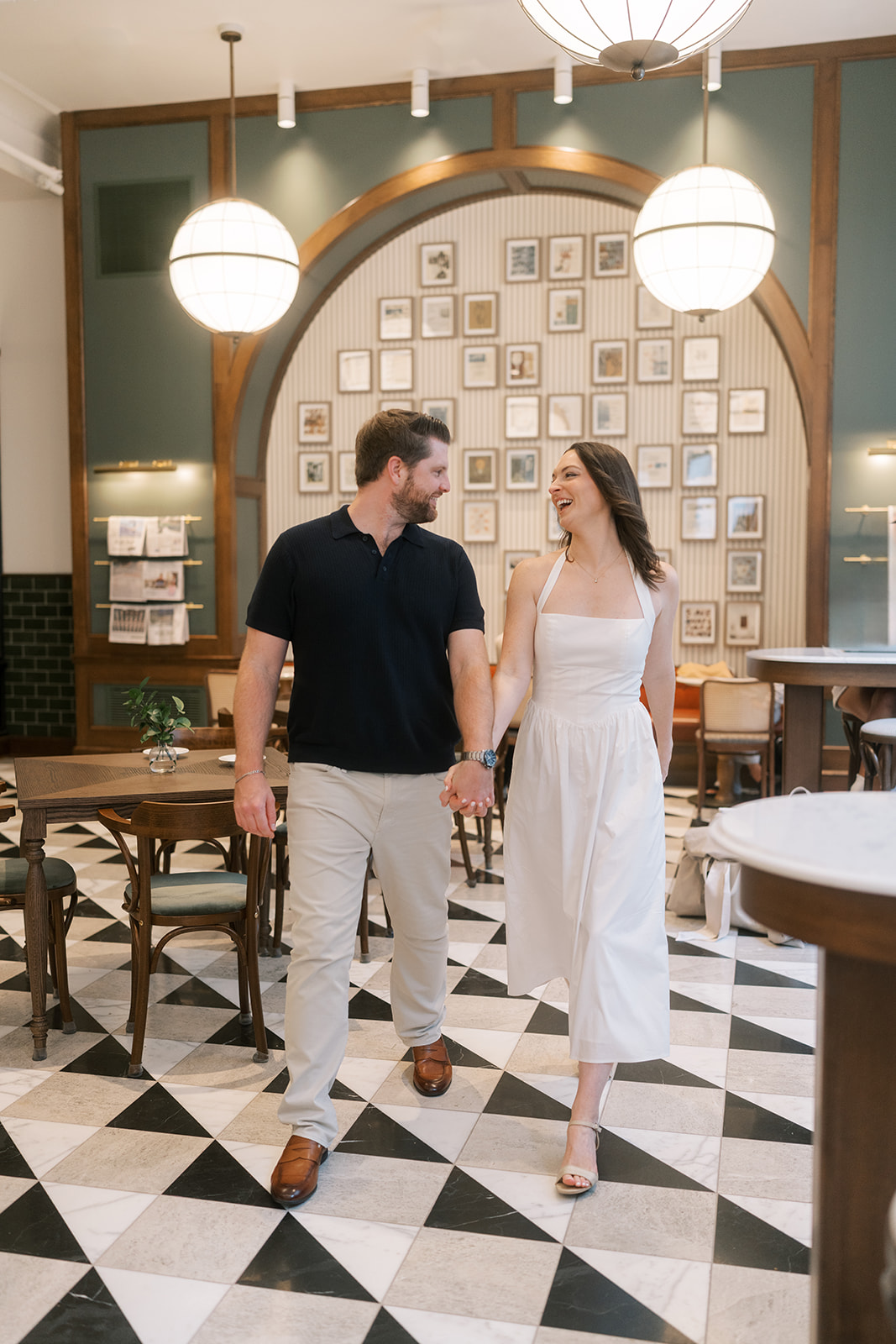 Full-length portrait of Frank and Noelle walking together across the café floor