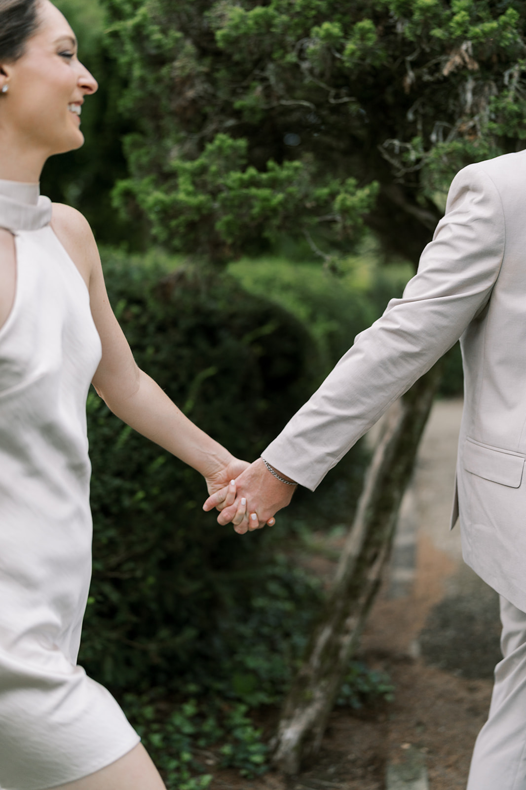 Close detail of Frank and Noelle holding hands in the garden