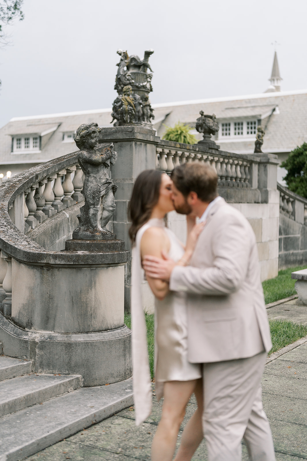 Frank and Noelle kissing beside Laurel Court's curved stone balustrade