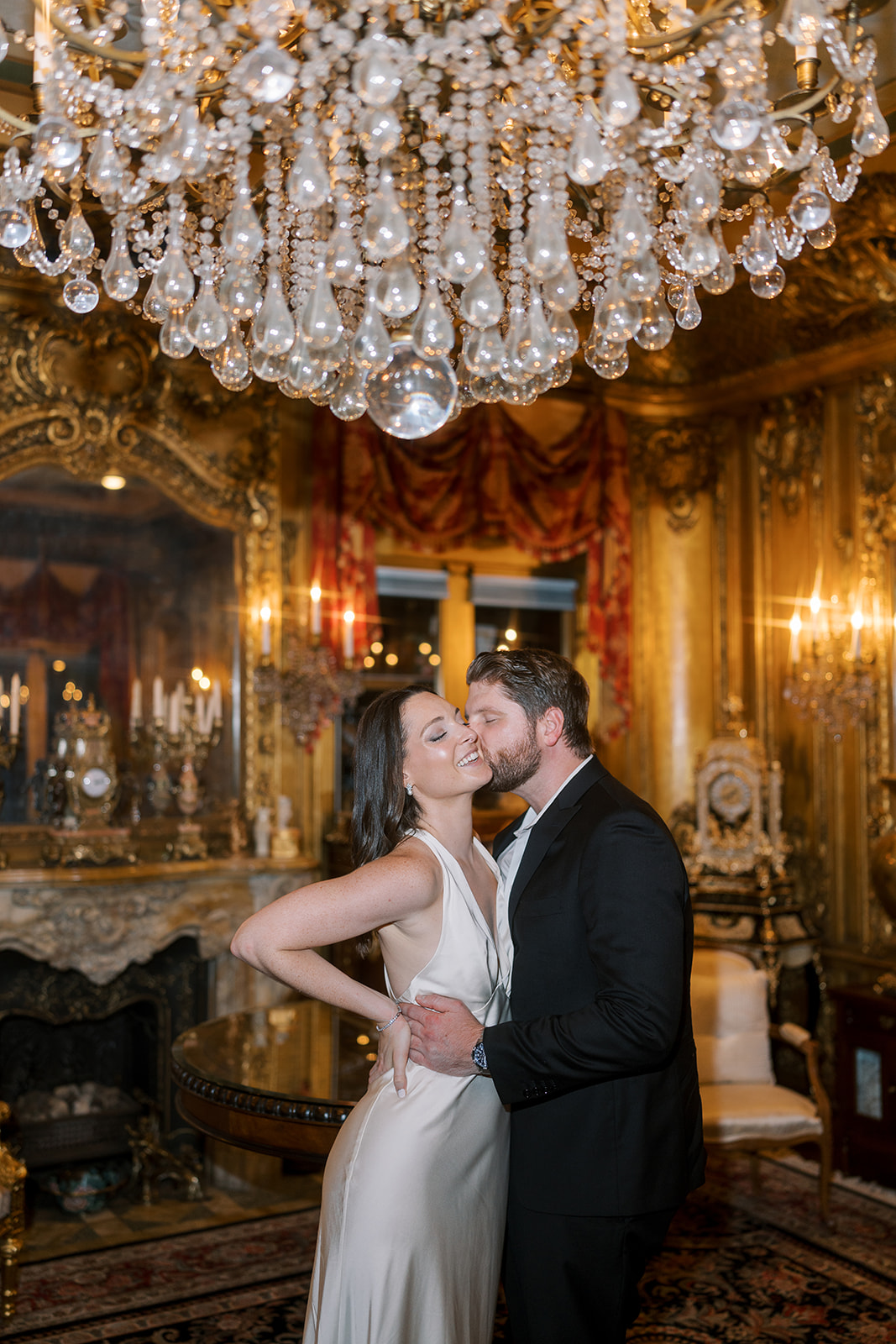 Frank and Noelle posing together beneath the chandelier in Laurel Court's gilded room