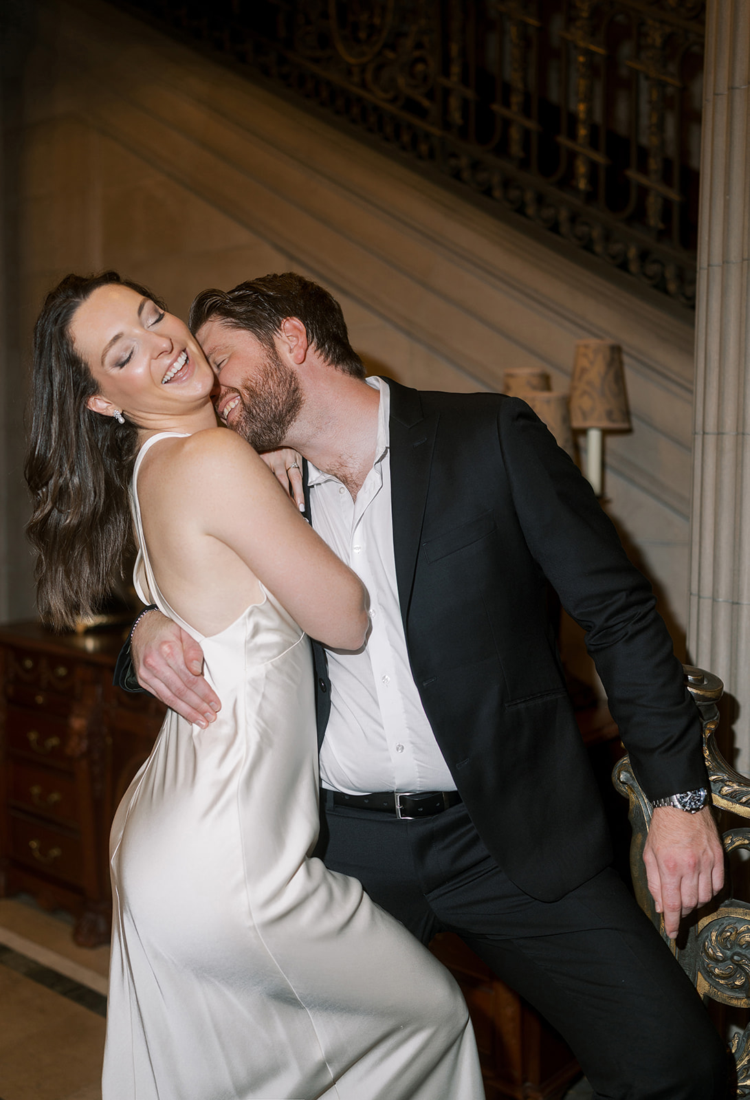 Frank and Noelle laughing together near Laurel Court's grand staircase