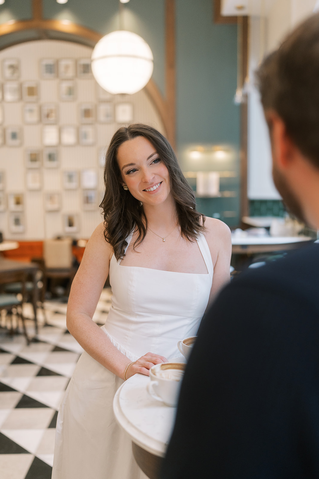 Portrait of Noelle seated in the café with Frank in the foreground