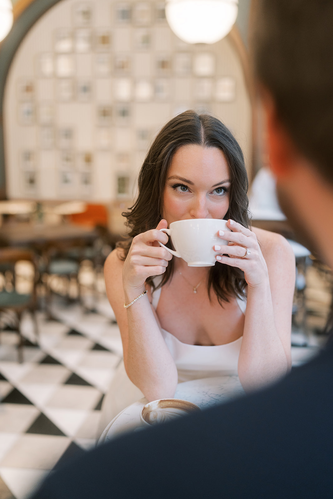 Noelle smiling while holding a coffee cup during the café portraits