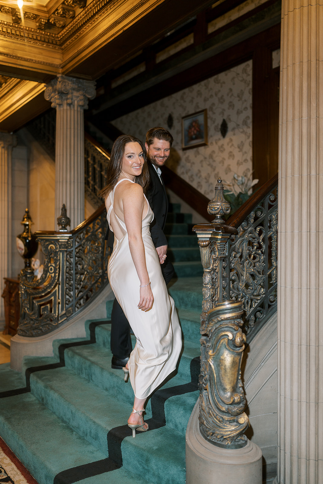 Noelle standing on Laurel Court's green-carpeted grand staircase