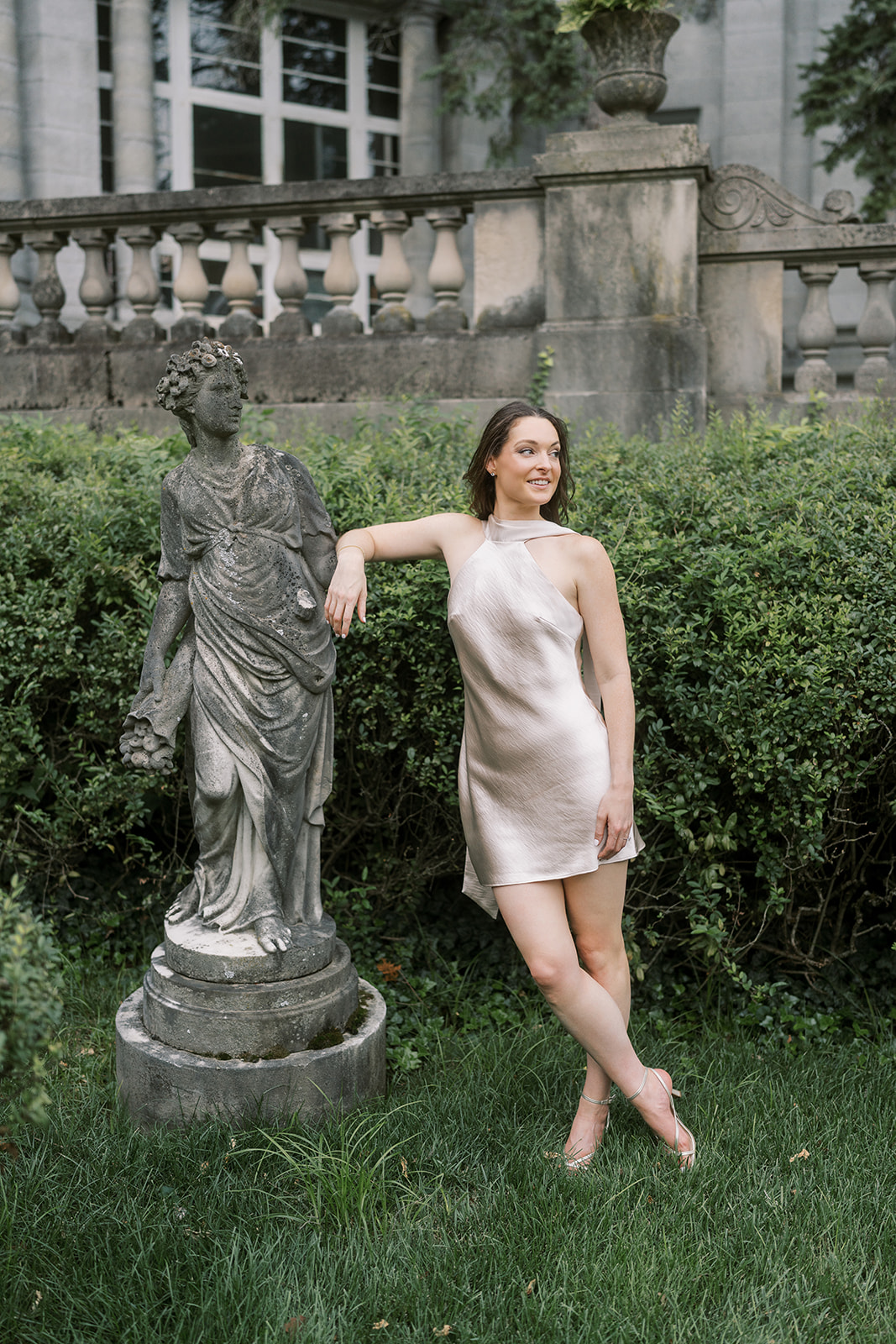 Noelle posing beside a classical garden statue at Laurel Court