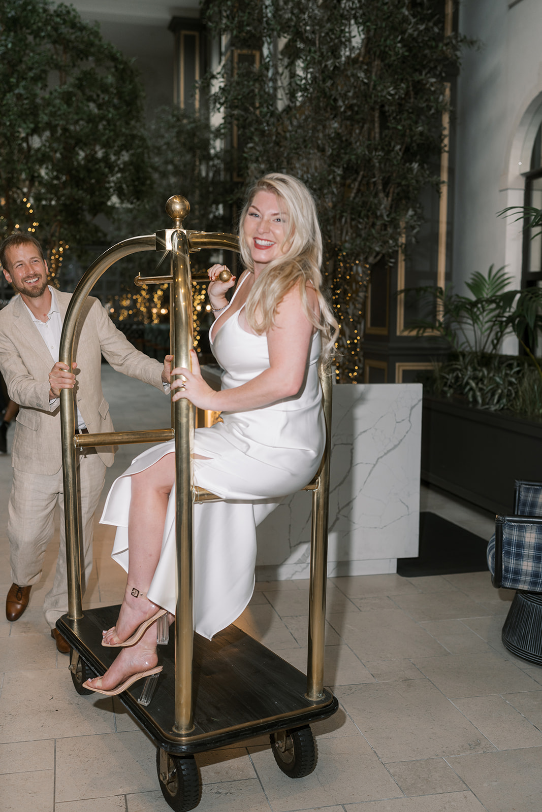 Autumn posing with a brass luggage cart in the hotel lobby