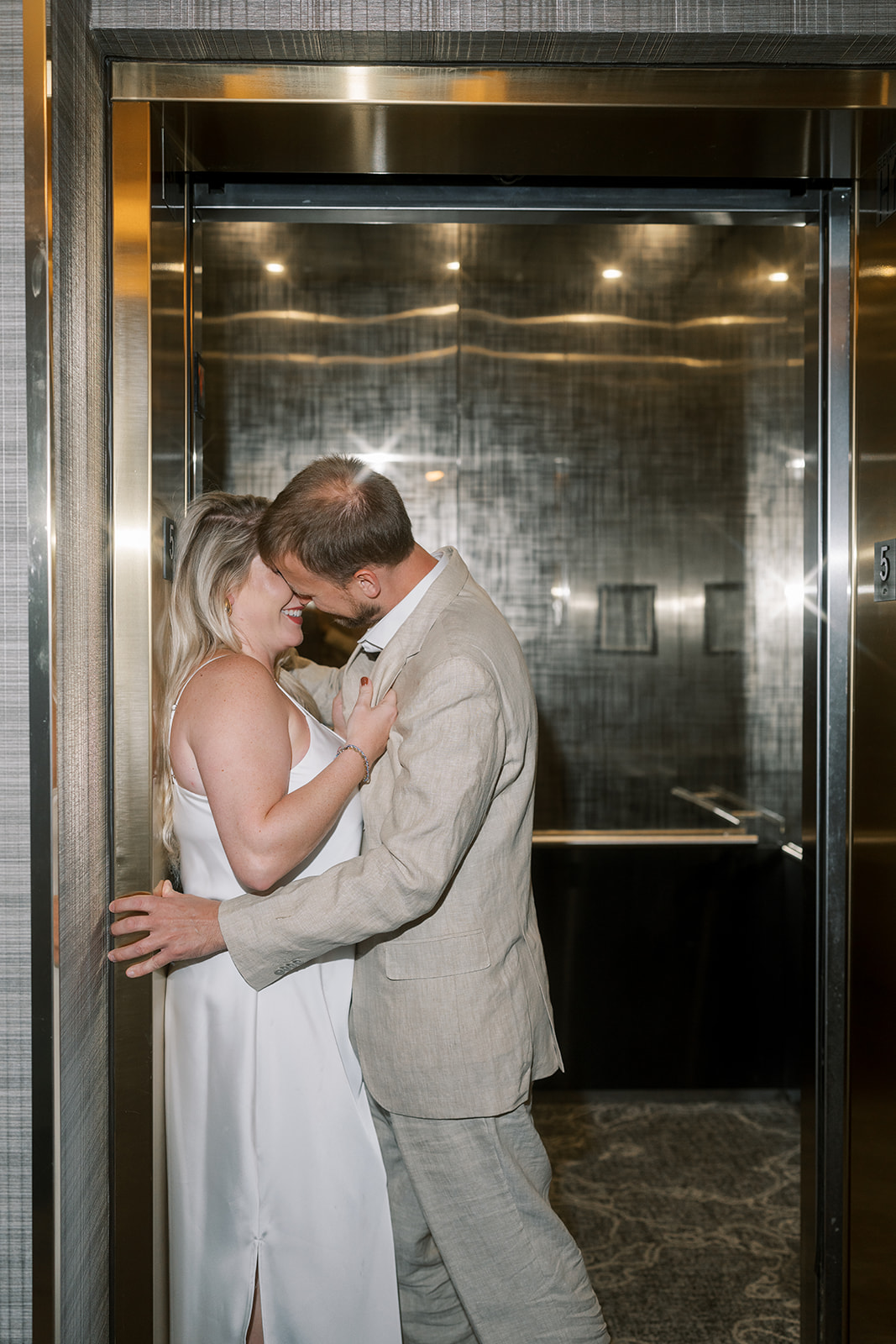 Josh and Autumn kissing inside a mirrored elevator