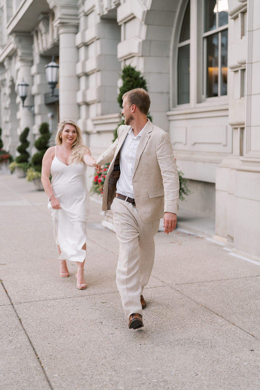 Josh and Autumn walking together along the hotel facade