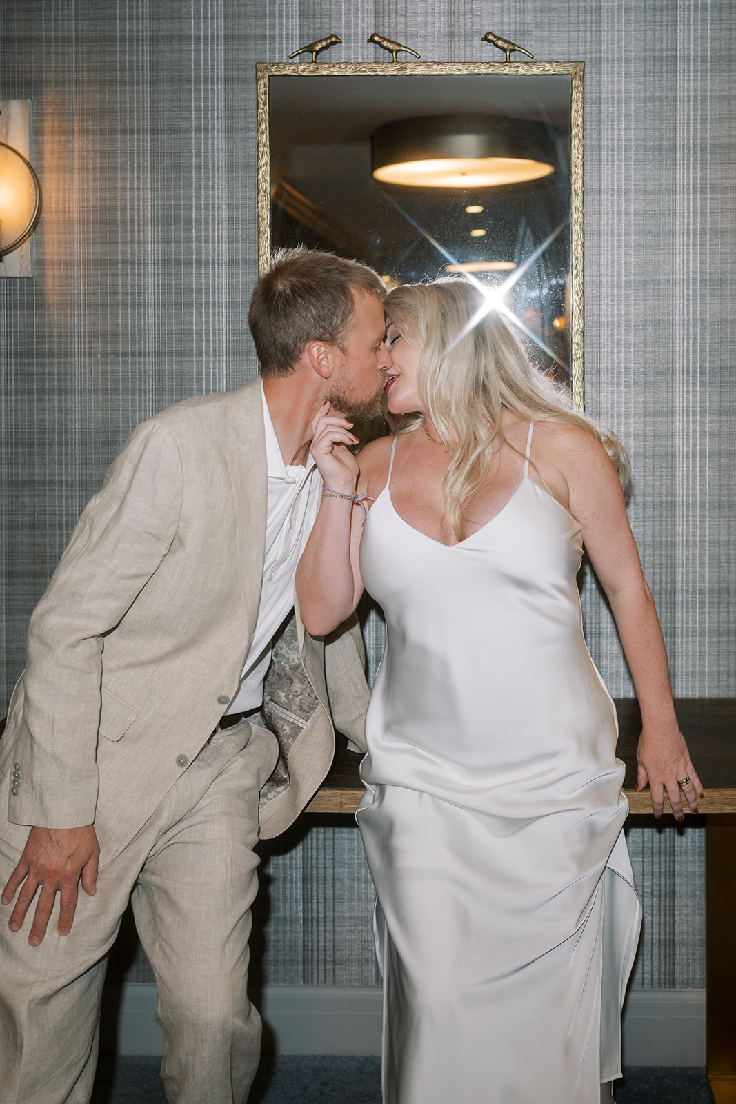 Josh and Autumn kissing in a hotel hallway