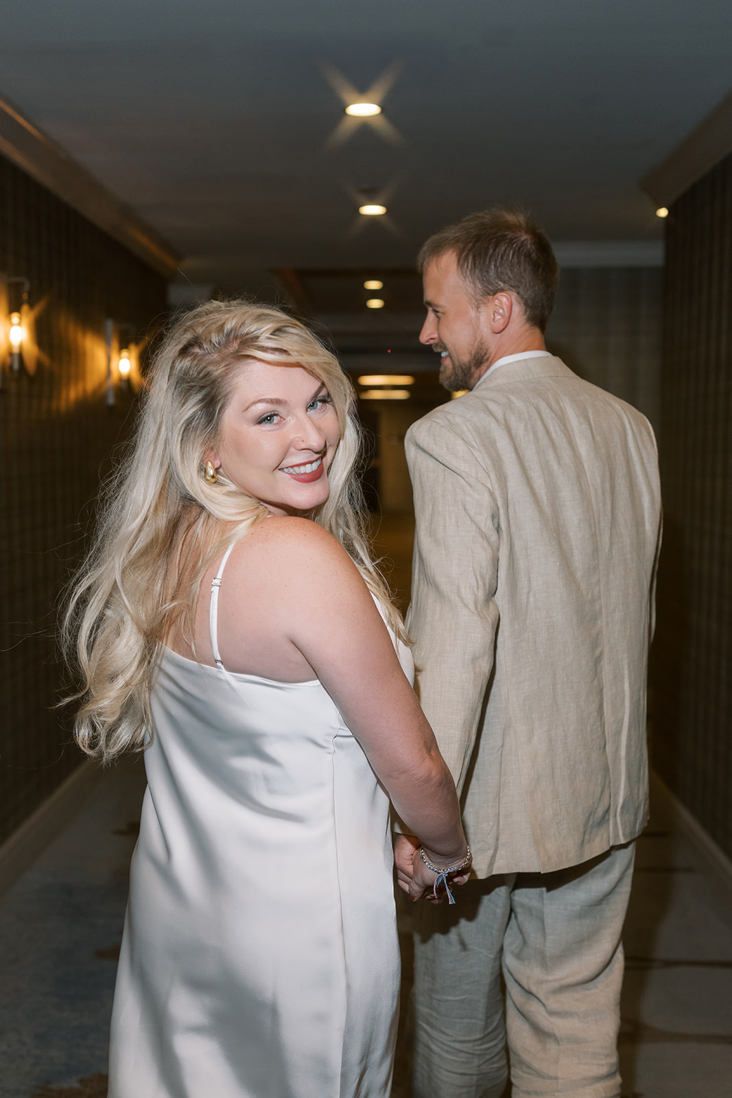Josh and Autumn walking together through a hotel hallway