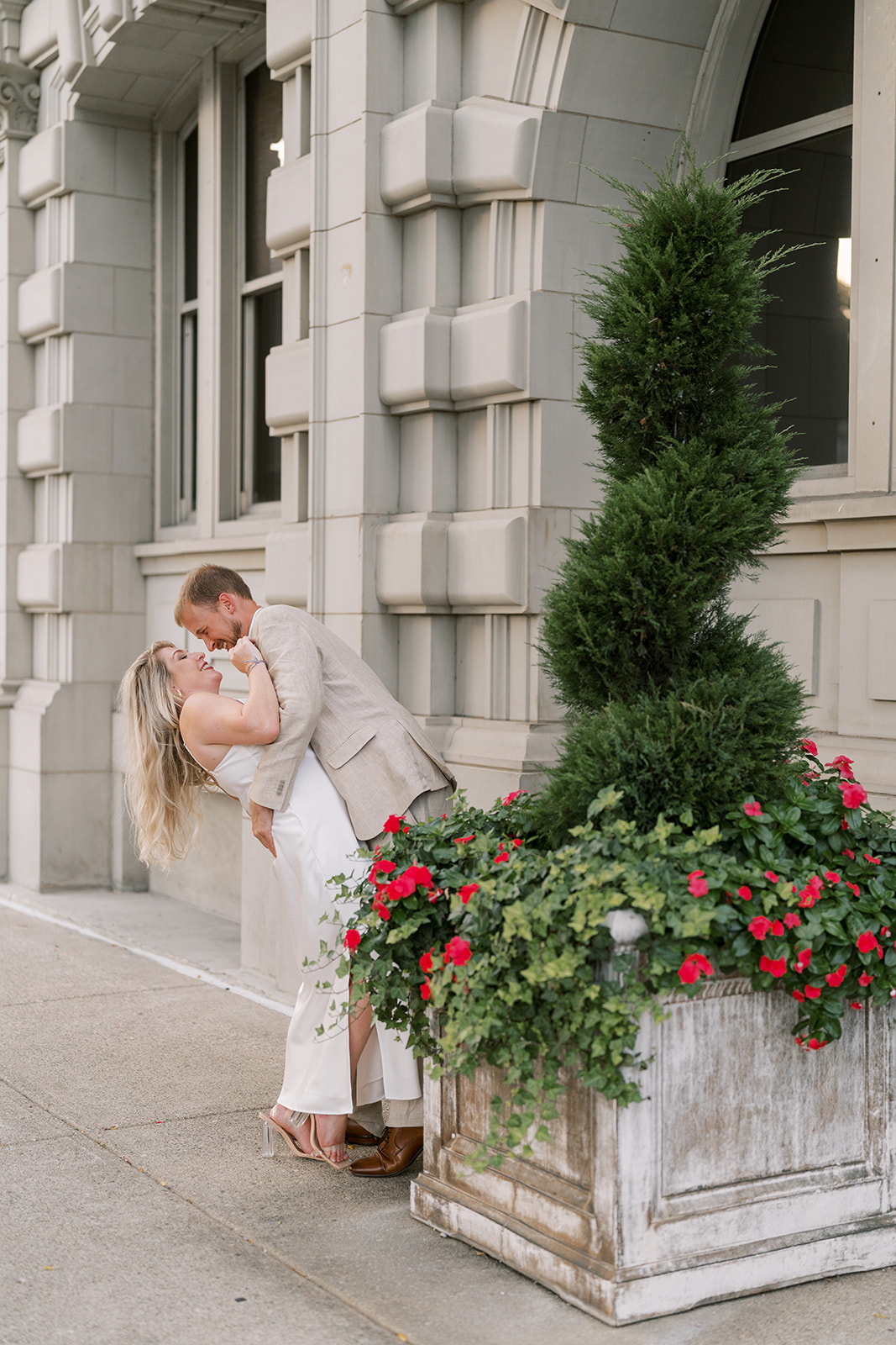 Josh and Autumn embracing in front of the hotel facade