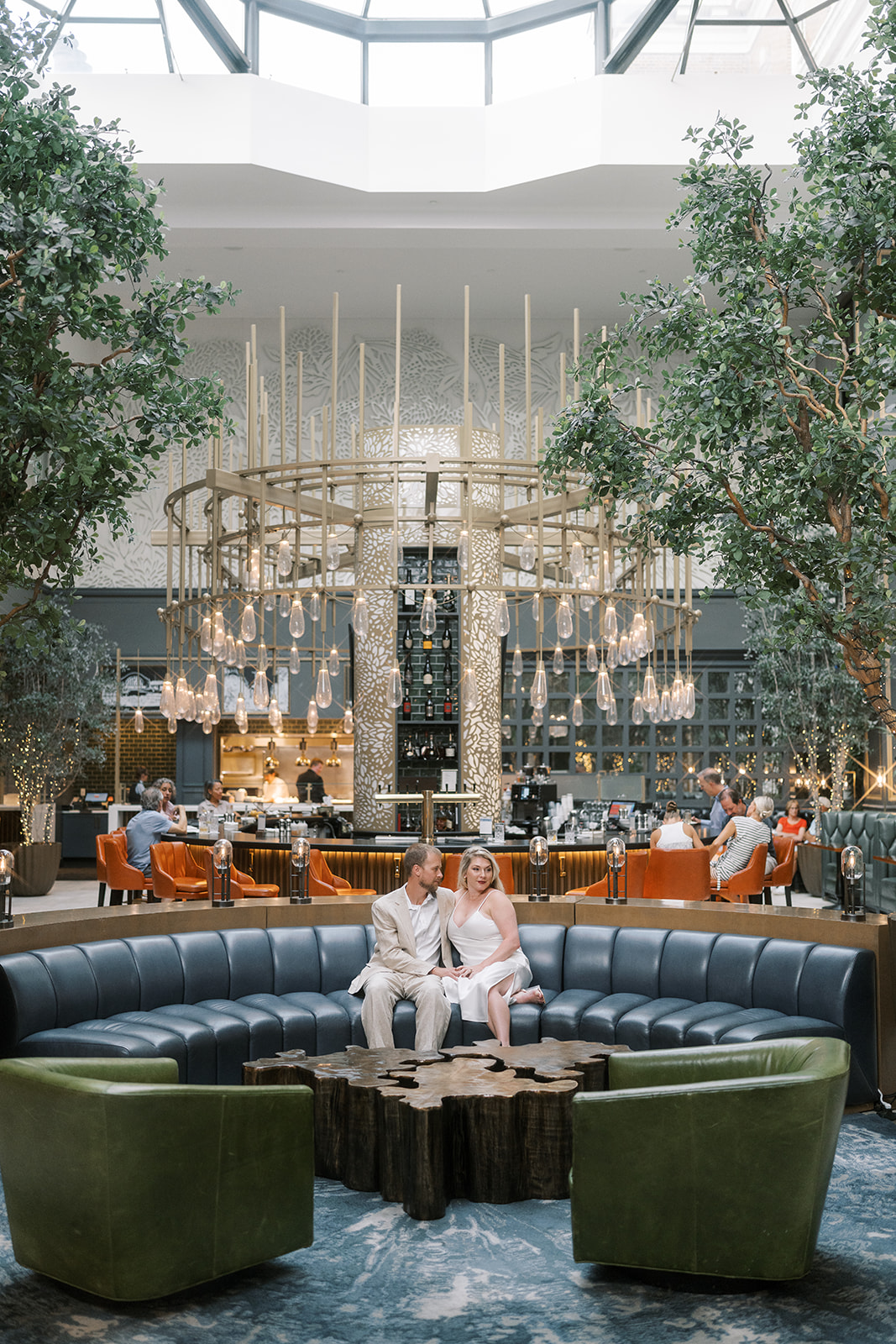 Wide portrait of Josh and Autumn in the Lytle Park Hotel lobby beneath the chandelier