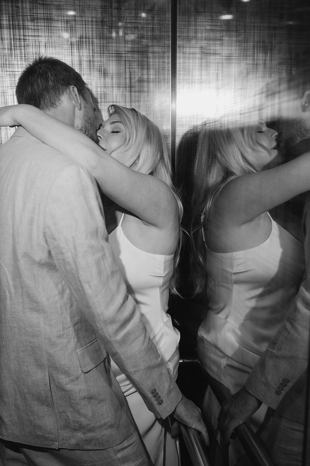 Josh and Autumn reflected together inside the mirrored elevator