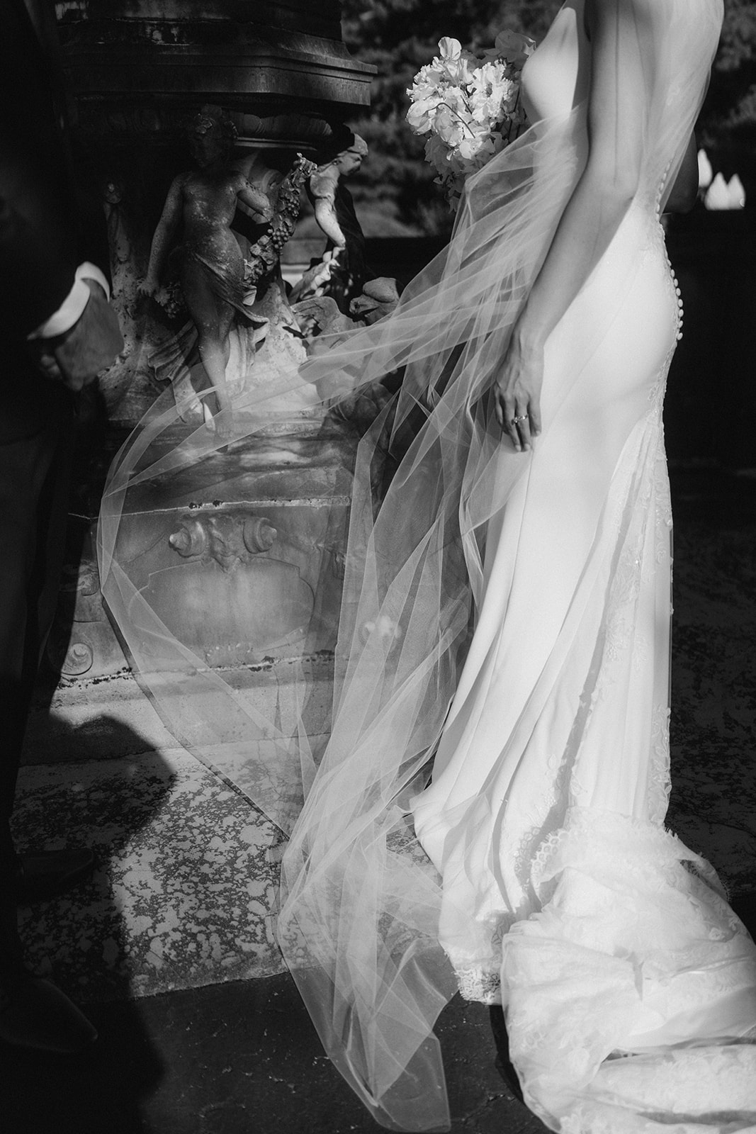 Black-and-white bridal portrait of Julia with her veil moving in the wind