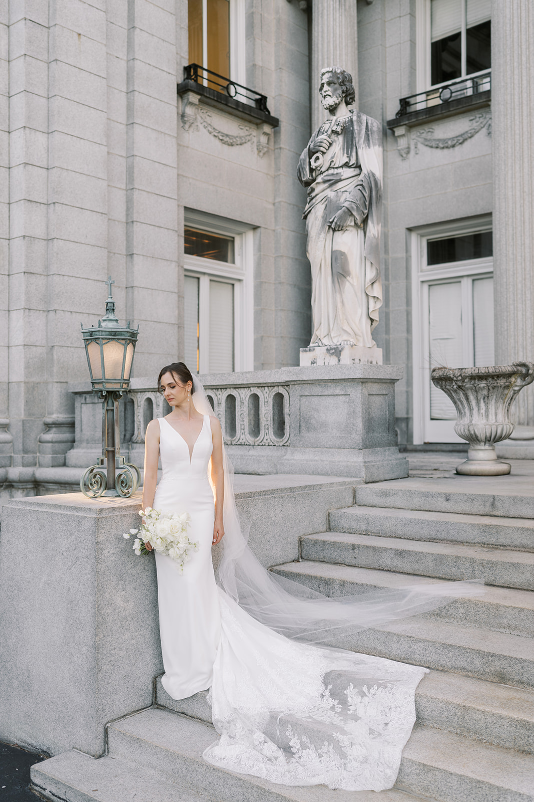 Julia posing in her wedding dress on the front steps of Laurel Court
