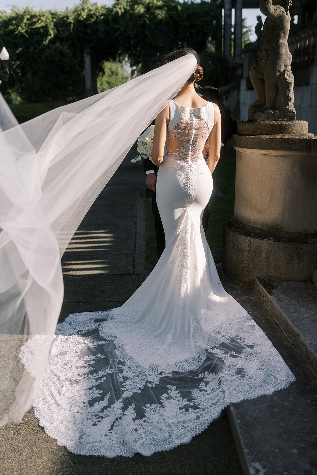 Back portrait of Julia showing her long veil and lace wedding train