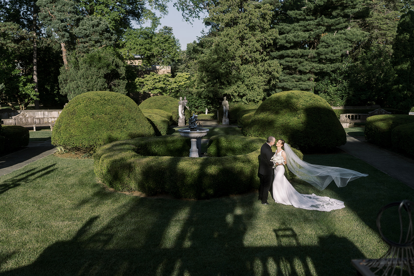 Wide view of Michael and Julia in the formal garden at Laurel Court