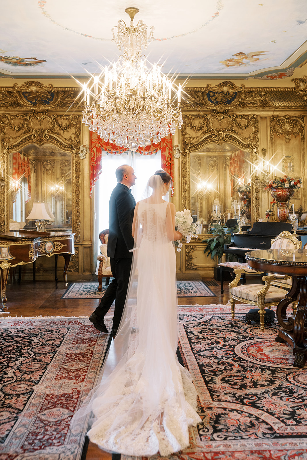 Michael and Julia framed in the doorway of a gilded interior room at Laurel Court