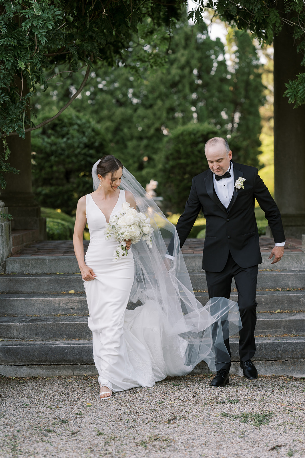 Michael and Julia walking hand in hand along a gravel path at Laurel Court