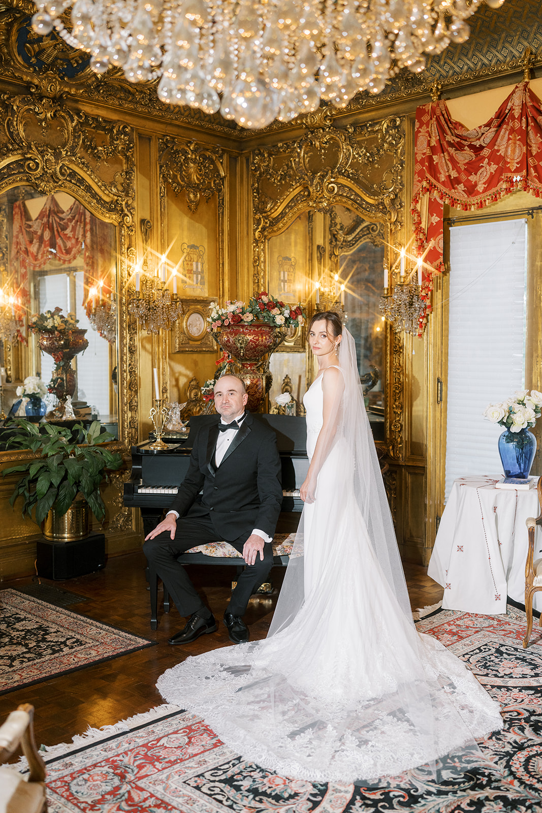 Michael and Julia posing beside the piano in an ornate room at Laurel Court