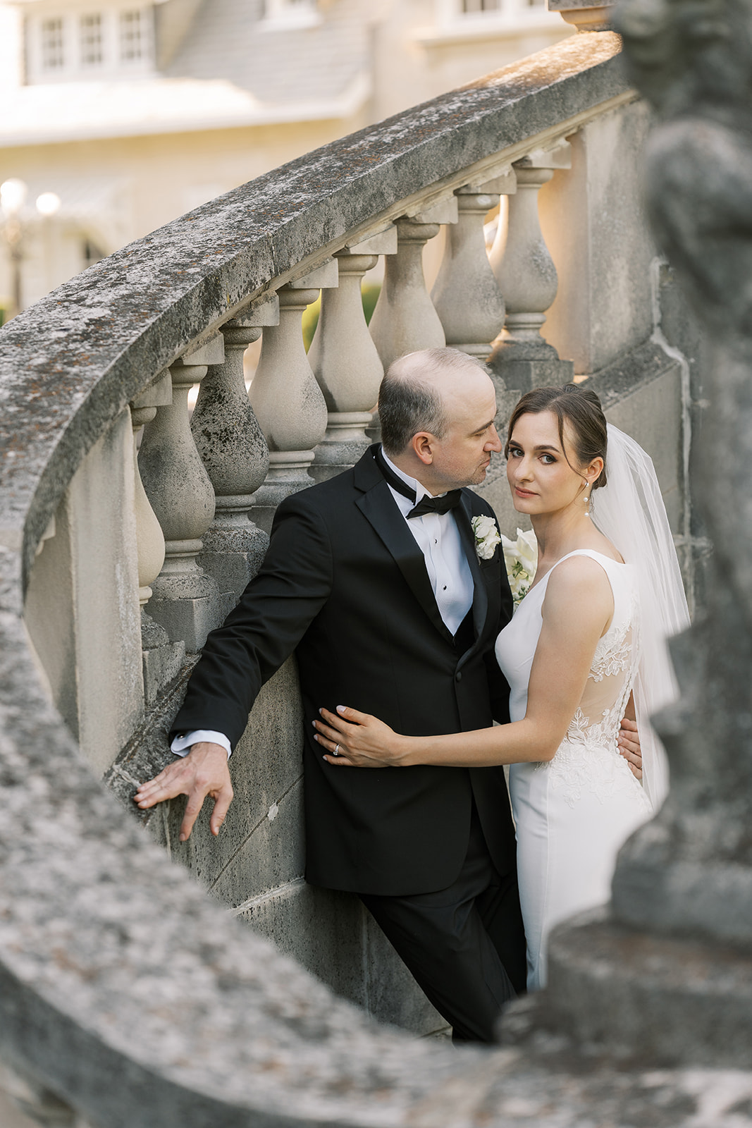 Michael and Julia embracing beside the stone balustrade at Laurel Court