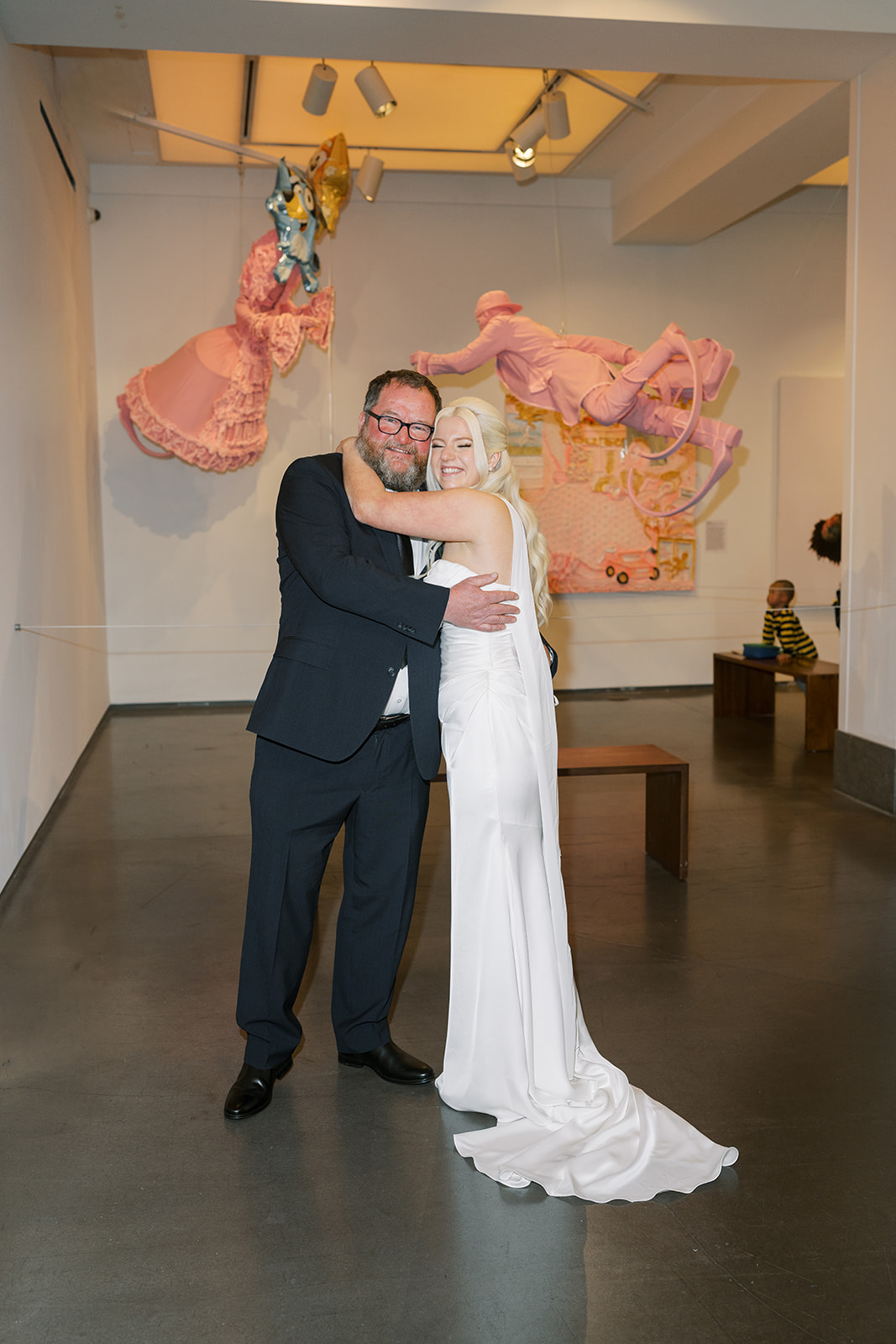 Niamh and Titus posing together in front of pink contemporary artwork at 21c Museum Hotel Cincinnati