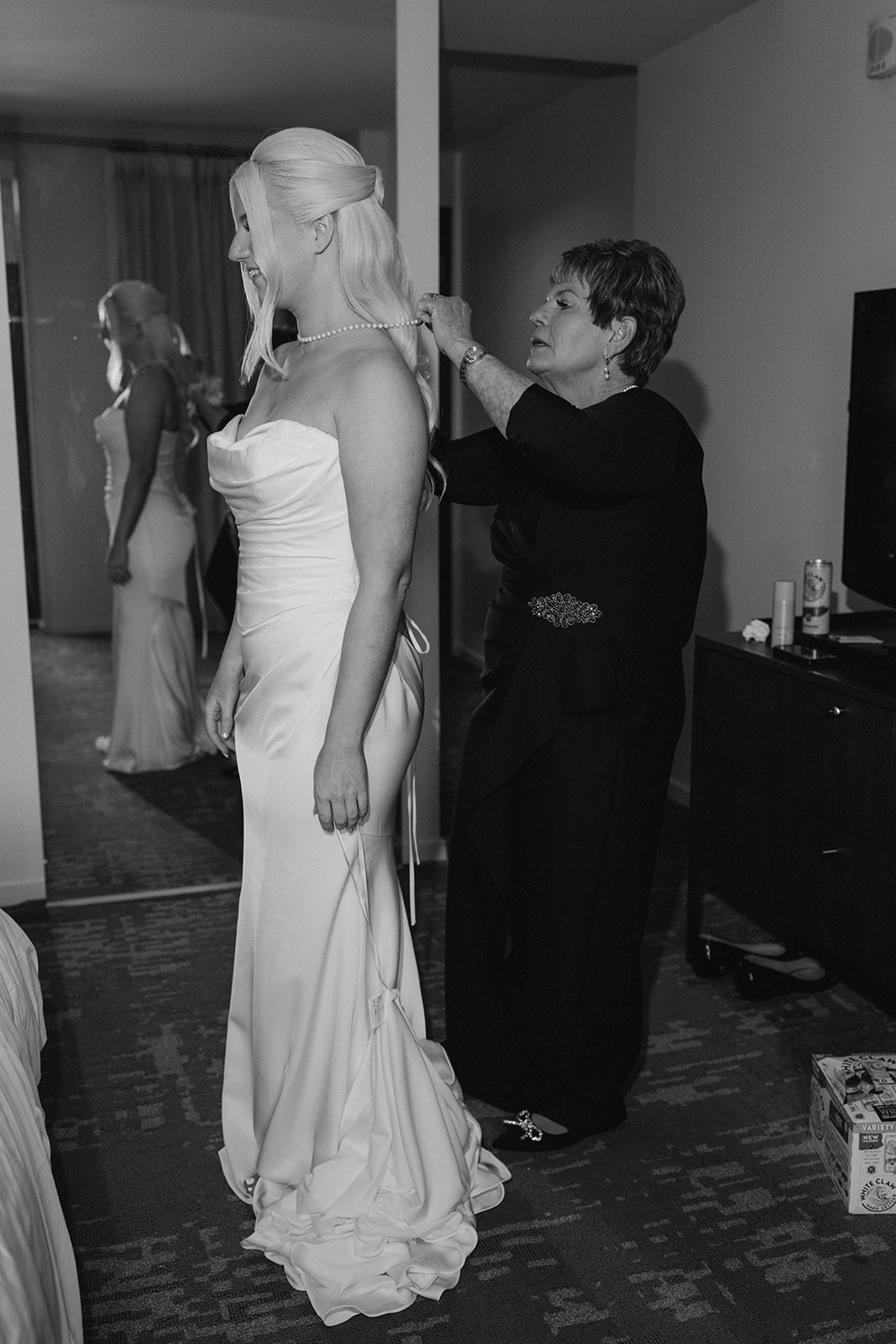 Black-and-white photograph of Niamh getting ready with a family member at 21c Museum Hotel Cincinnati