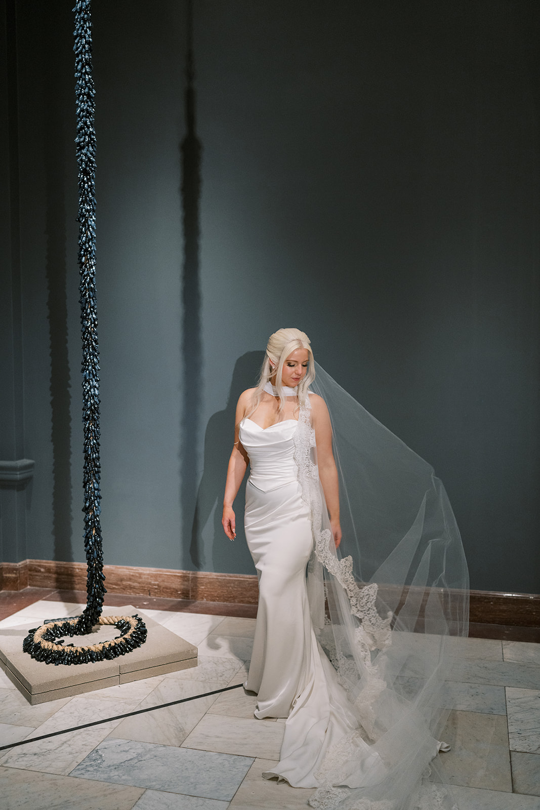 Niamh in her wedding gown inside a dark Cincinnati Art Museum gallery