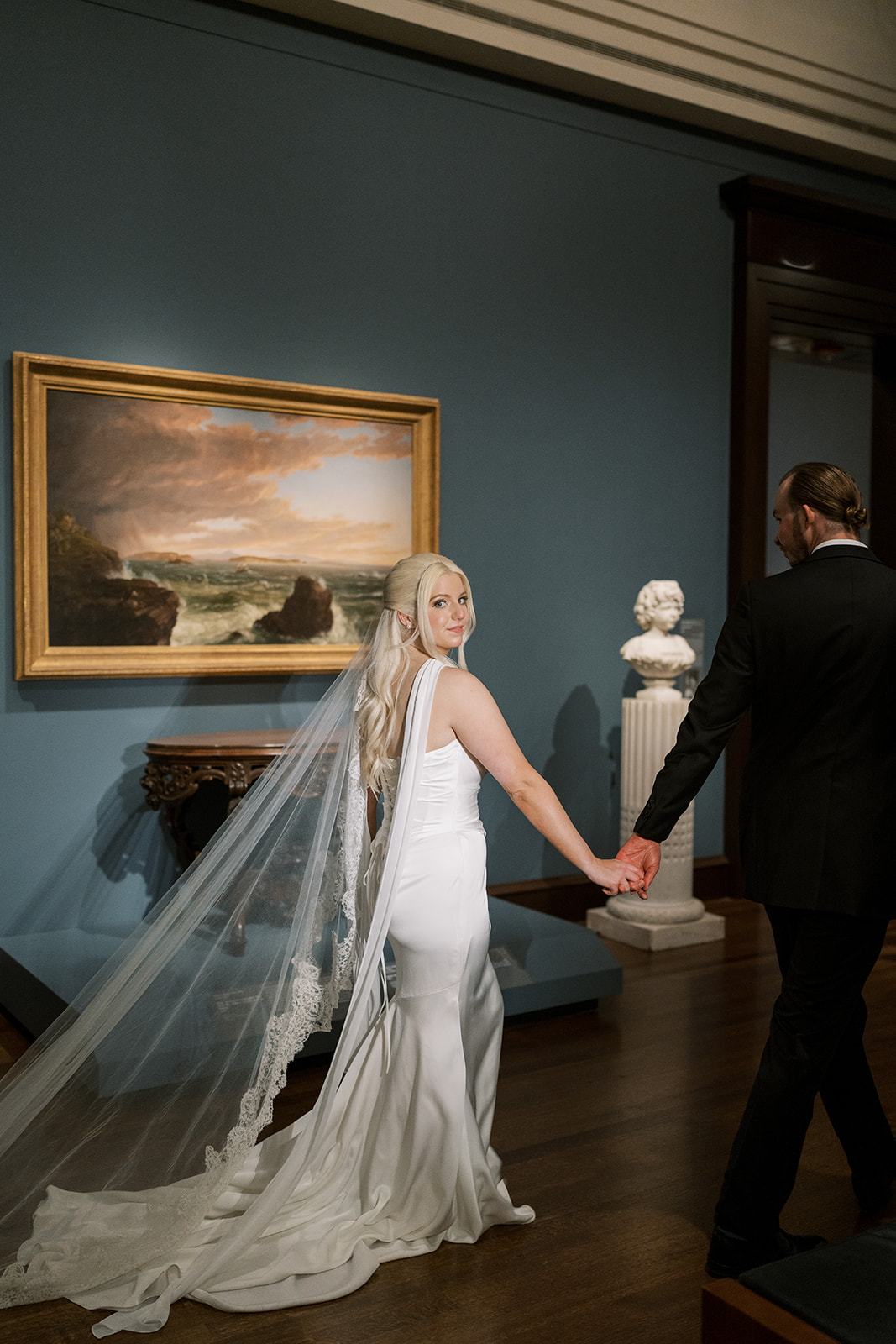 Niamh and Titus walking hand in hand through a Cincinnati Art Museum gallery