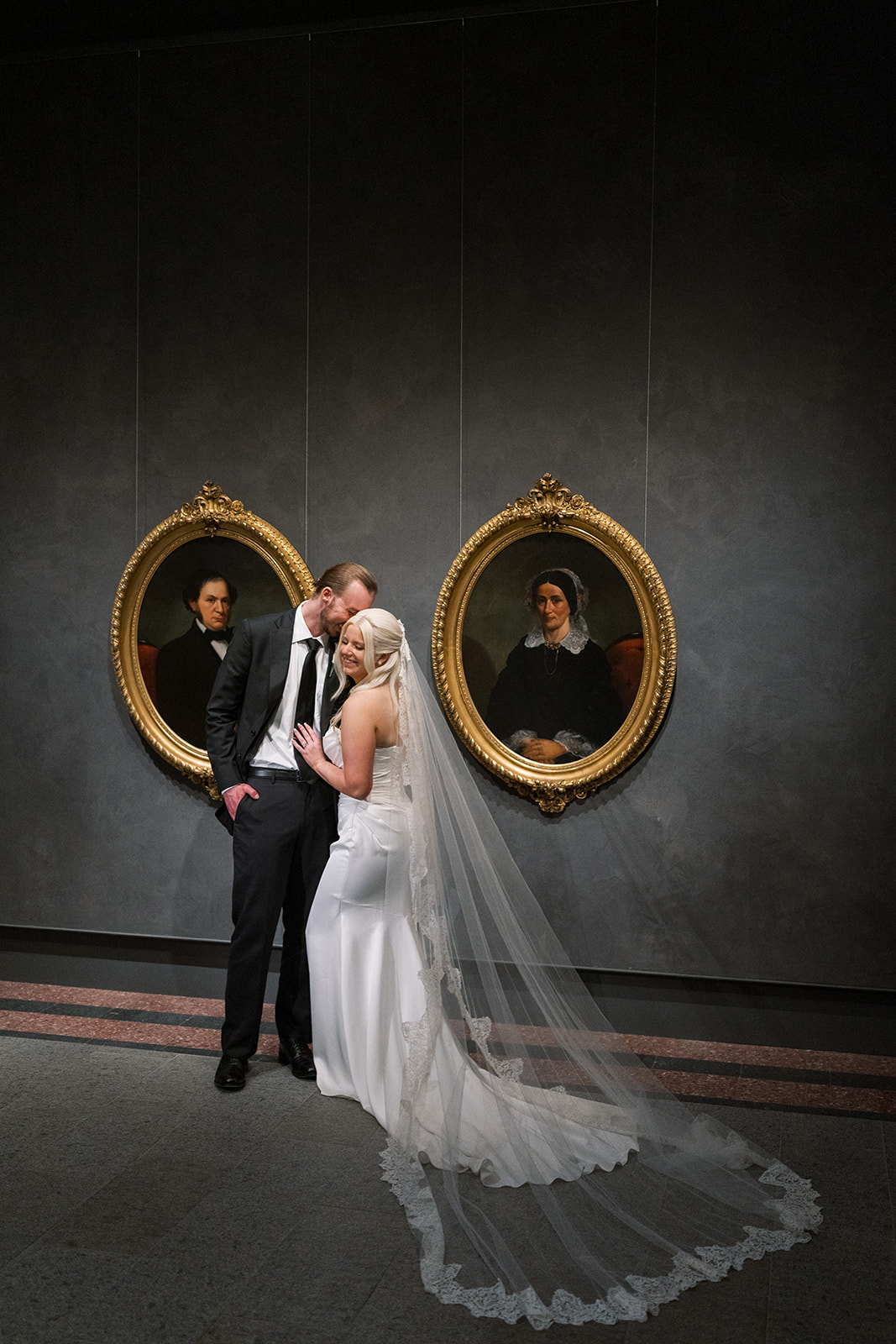 Niamh and Titus standing beneath paired oval portraits at Cincinnati Art Museum