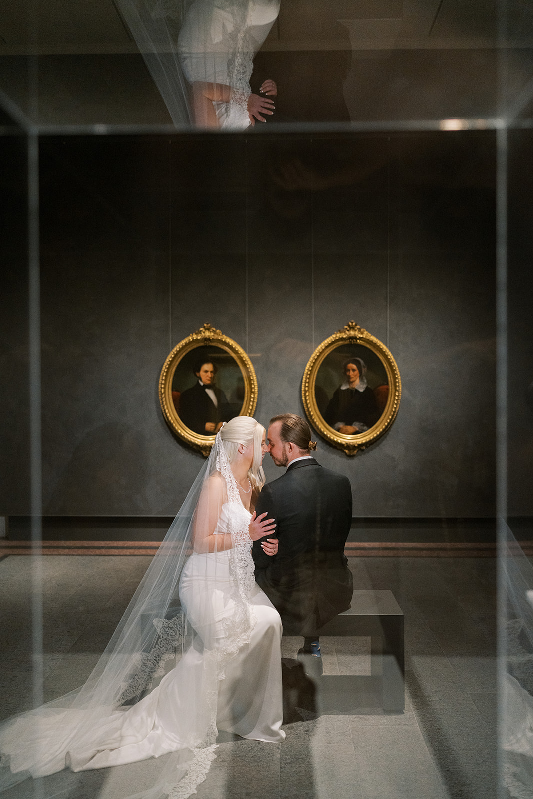 Niamh and Titus reflected beneath a pair of oval portraits at Cincinnati Art Museum