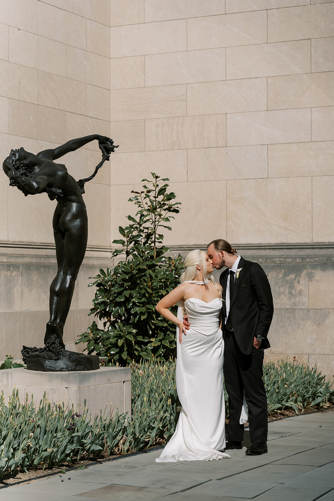 Niamh and Titus posing beside an outdoor sculpture at Cincinnati Art Museum