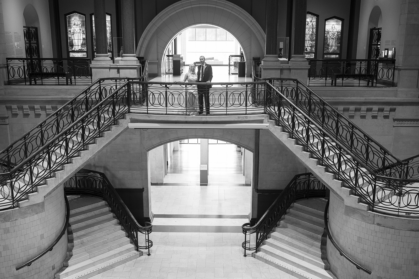 Symmetrical black-and-white view of Niamh and Titus on Cincinnati Art Museum's grand staircase