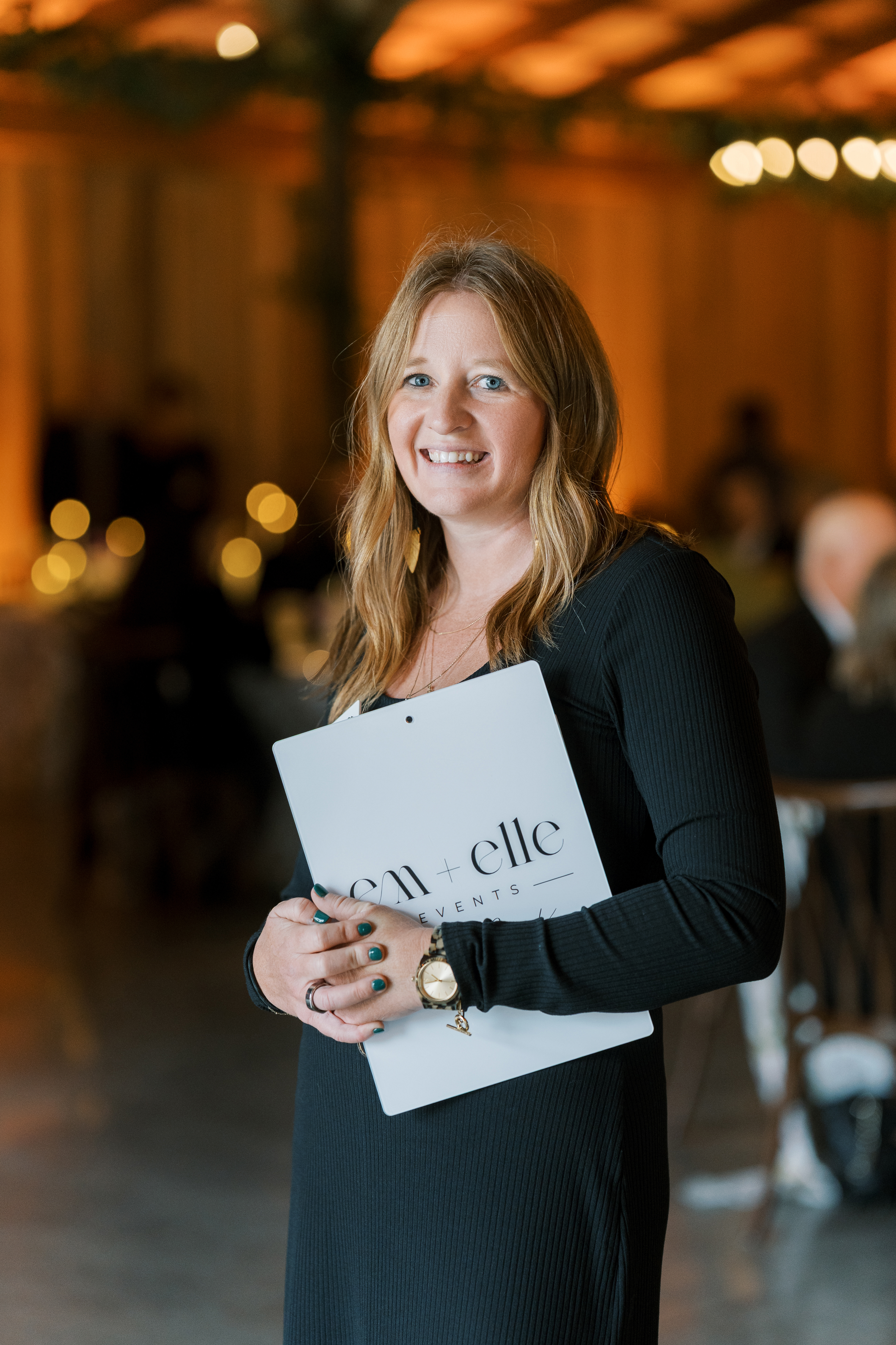 Leeann McKay of Em + Elle Events holding an Em + Elle planning folder during a wedding photographed by Olga Polo Weddings