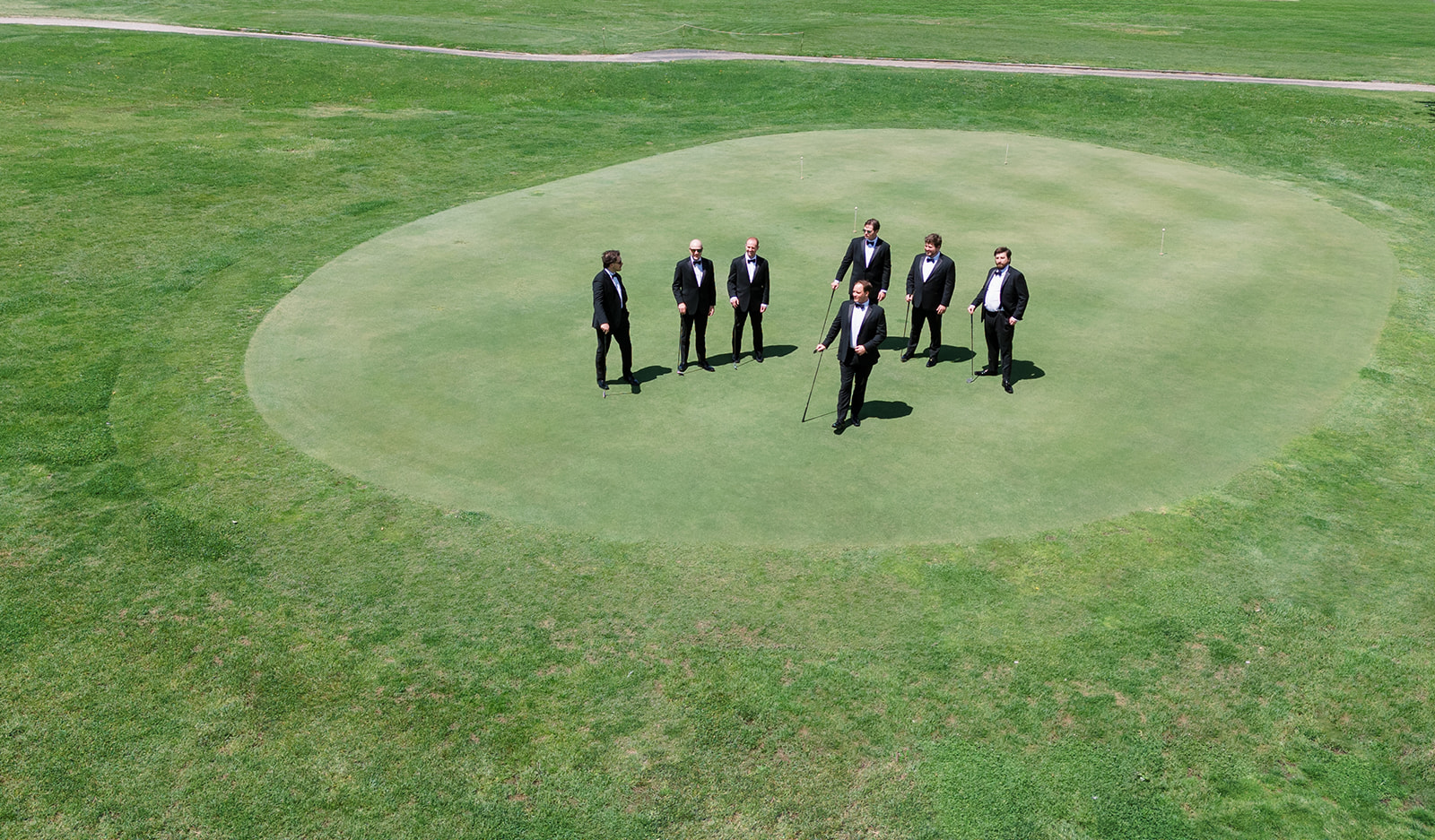 Ben and his groomsmen arranged across a putting green on the wedding day