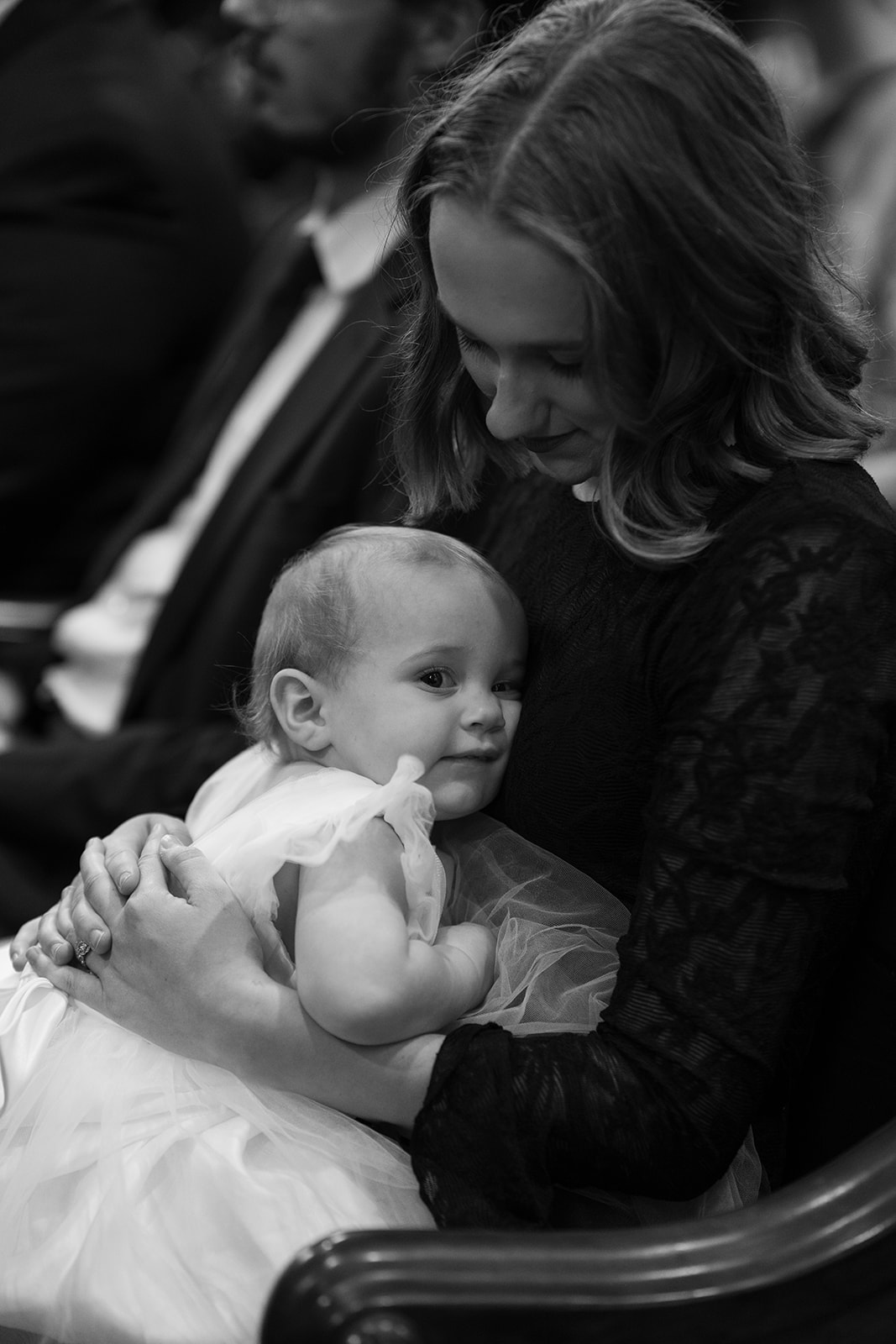 Black-and-white candid of a young wedding guest inside Mother of God Church