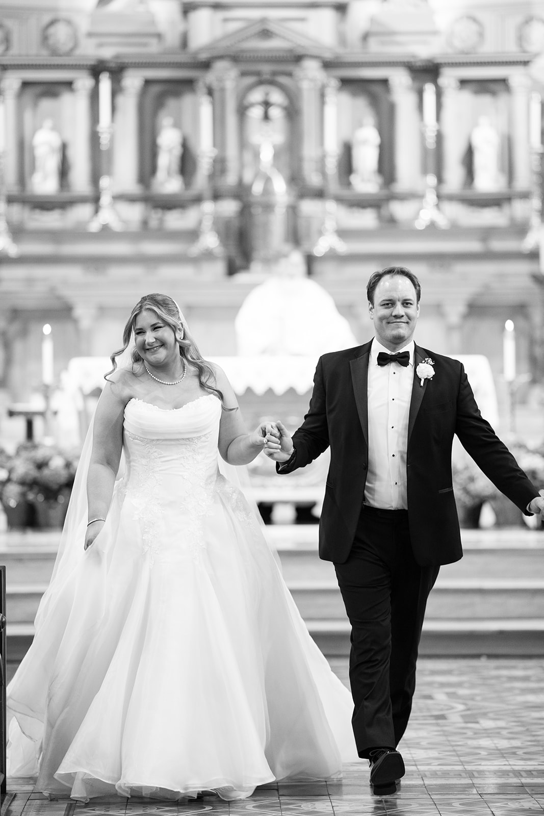 Black-and-white portrait of Ben and Hannalee walking together inside Mother of God Church