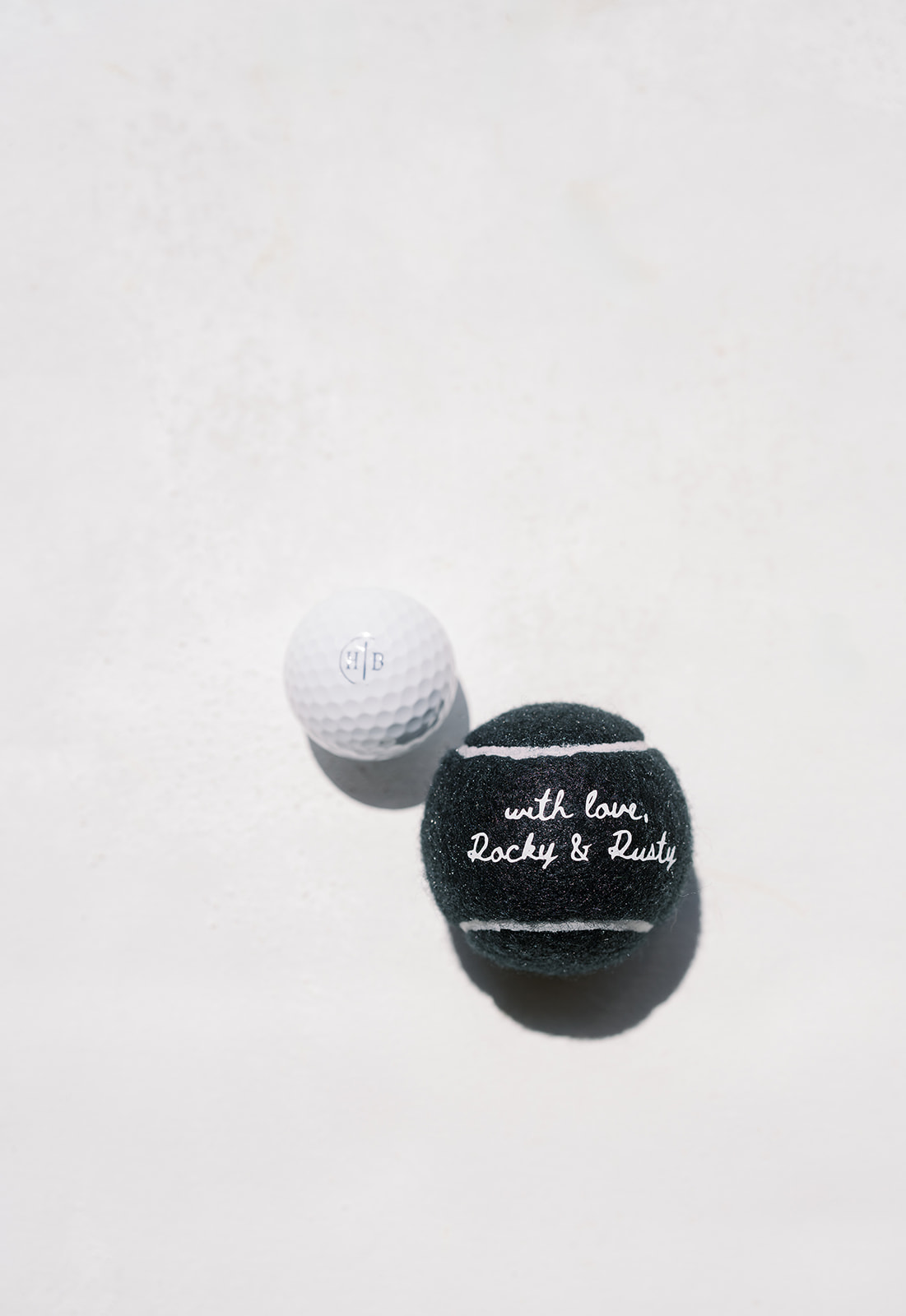 Black and white monogrammed golf balls styled with wedding details