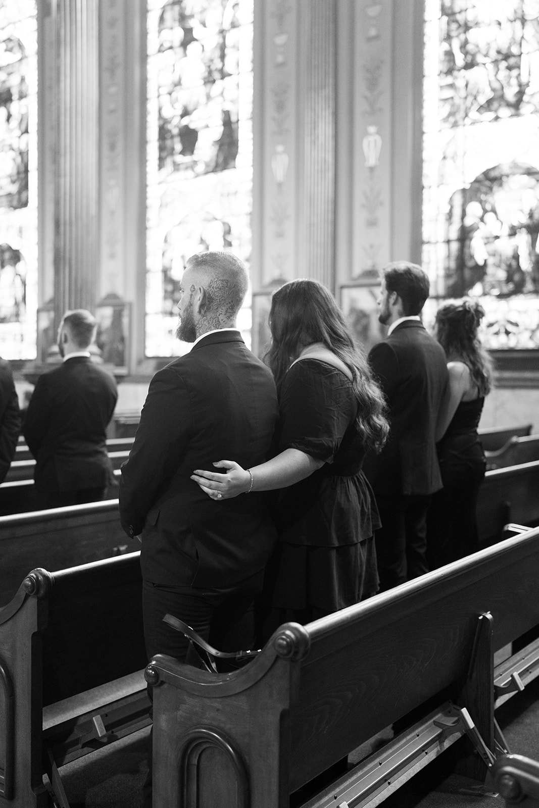 Black-and-white candid of guests standing inside Mother of God Church